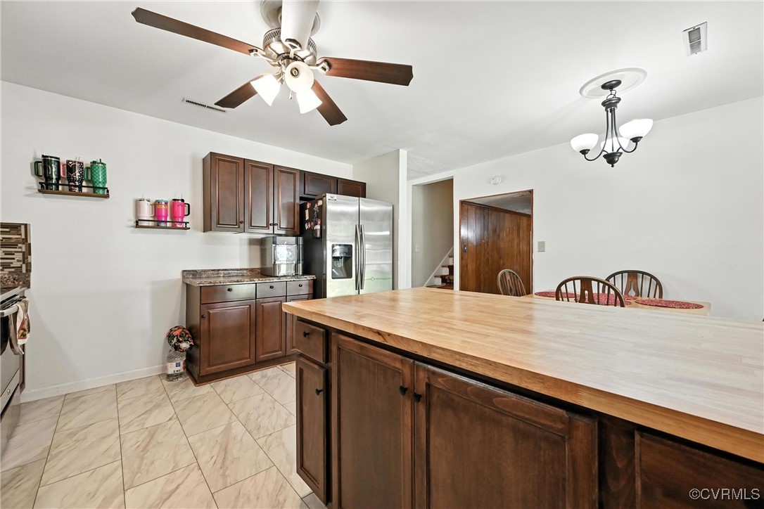 1593 Baxter Road Prince George, VA 23875 - Photo 7 of 48 a kitchen with kitchen island a stove a sink and a refrigerator with wooden floor