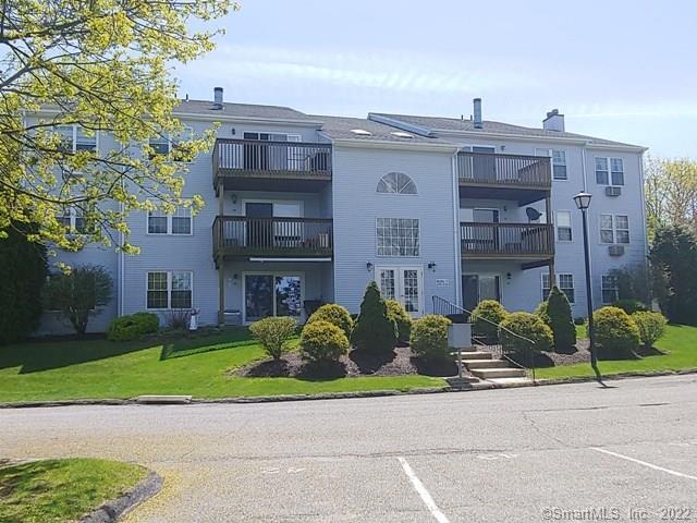 a front view of a building with a garden and plants