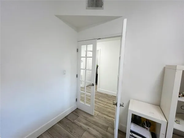a bedroom with bed and flat tv screen on the dresser