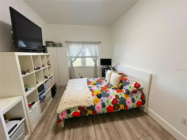 a view of a hallway with wooden floor and a bathroom