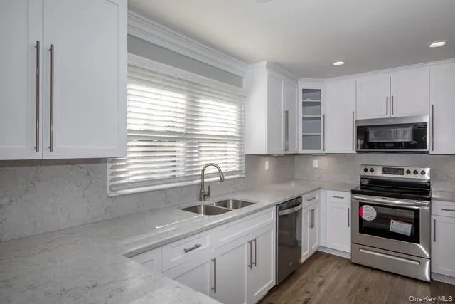 a kitchen with stainless steel appliances a stove sink and microwave
