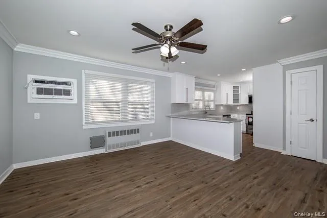 a view of a kitchen with wooden floor and a ceiling fan