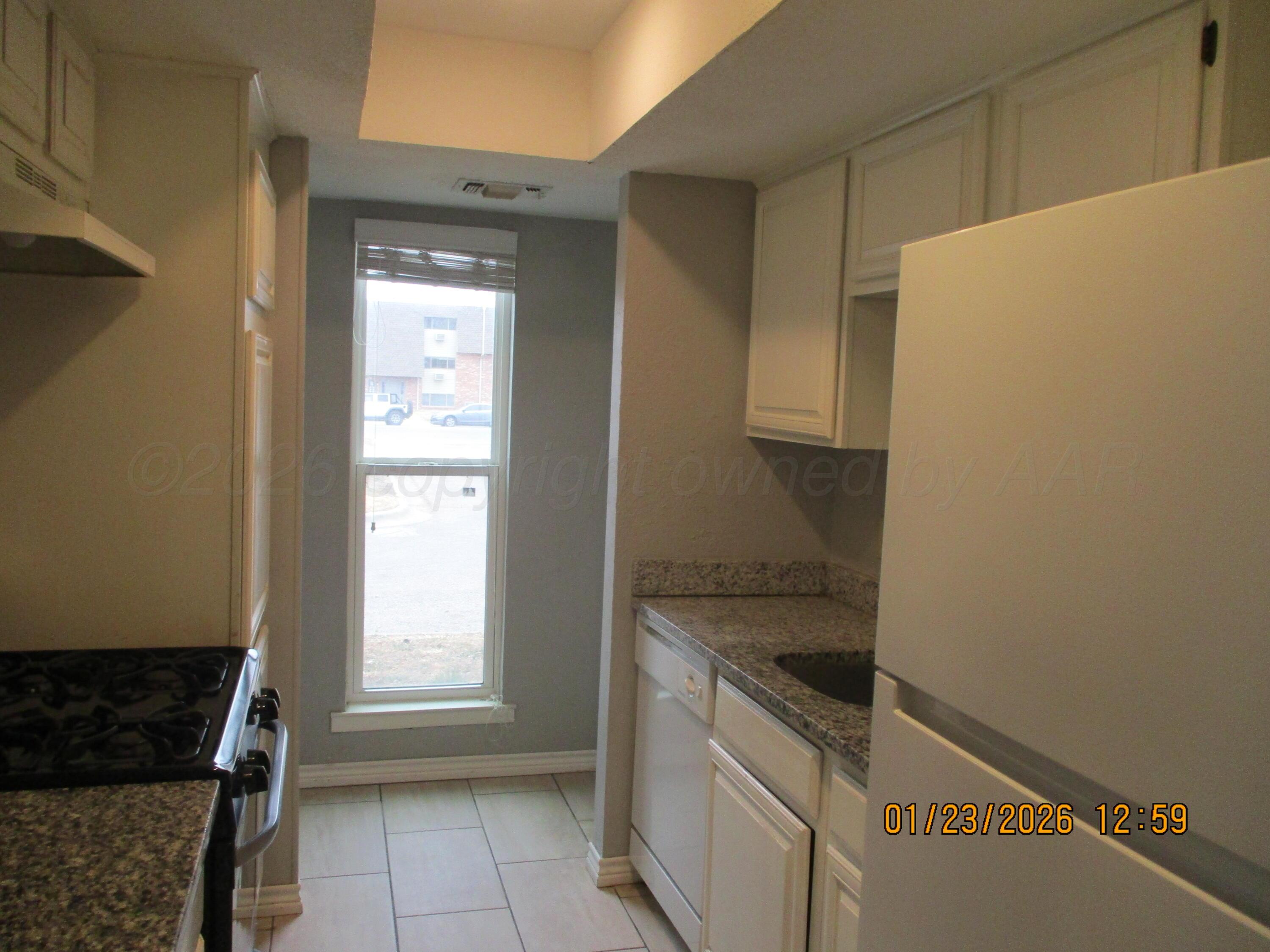 4500 South Virginia Street Amarillo, TX 79109 - Photo 5 of 8 a kitchen with a refrigerator and a stove top oven