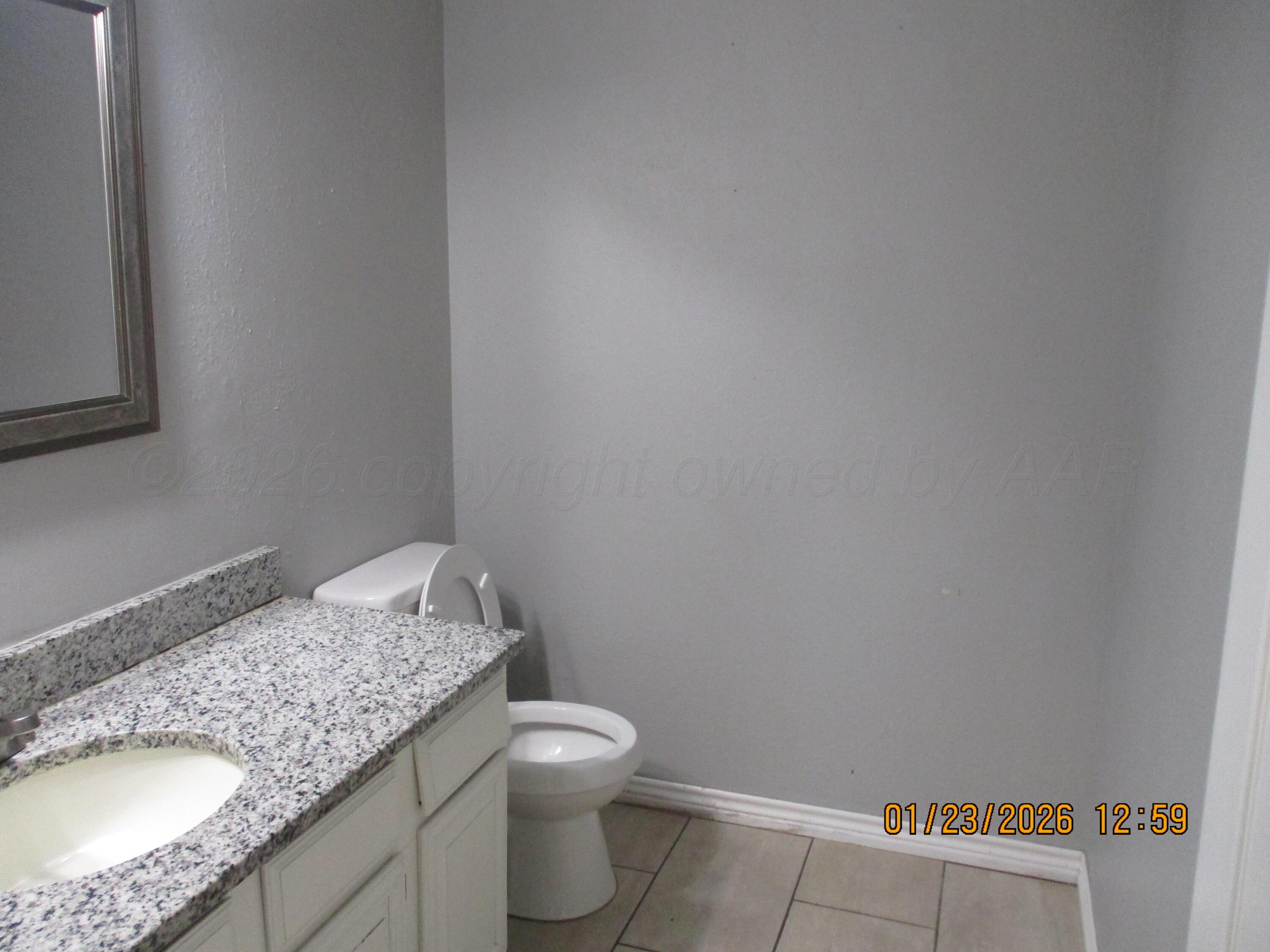 4500 South Virginia Street Amarillo, TX 79109 - Photo 7 of 8 a bathroom with a granite countertop sink and toilet