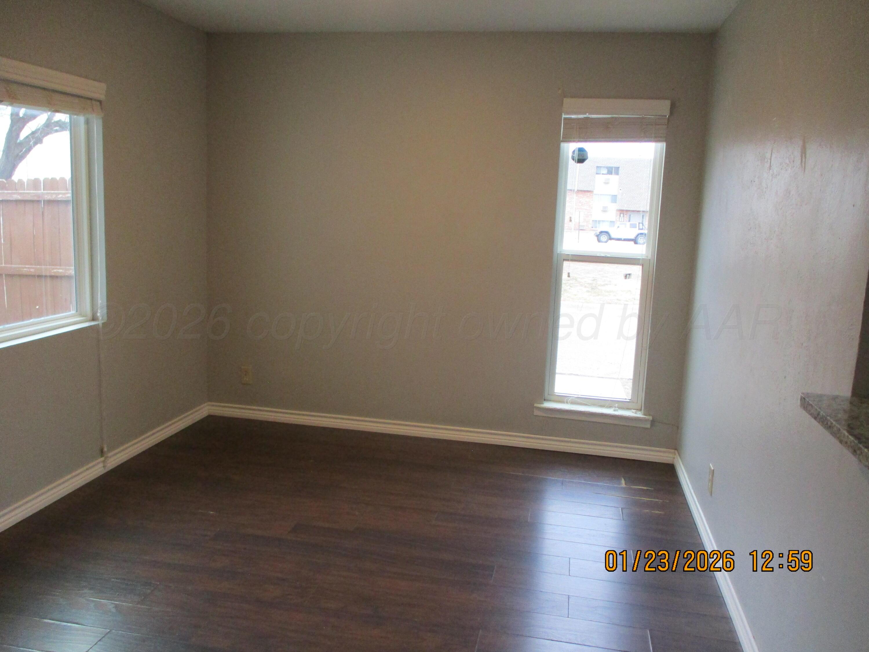 4500 South Virginia Street Amarillo, TX 79109 - Photo 8 of 8 an empty room with wooden floor and windows