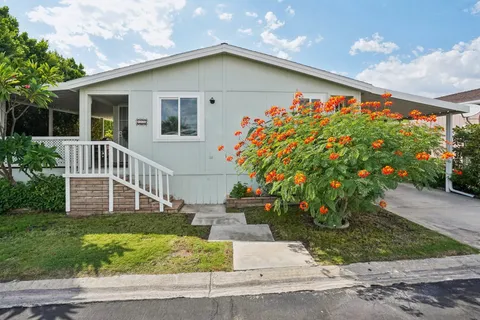 a front view of a house with a yard and potted plants