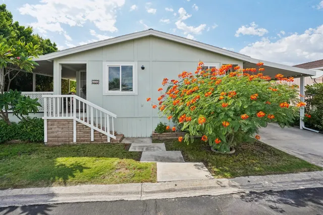 a front view of a house with a yard and potted plants