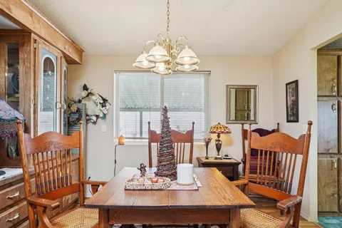a view of a dining room with furniture a chandelier and wooden floor