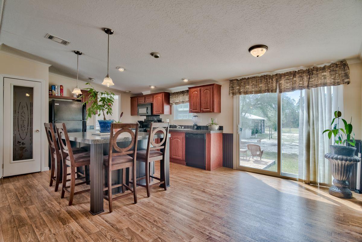 332 Don Graff Road Freeport, FL 32439 - Photo 12 of 33 a view of a dining room and livingroom with furniture wooden floor a chandelier