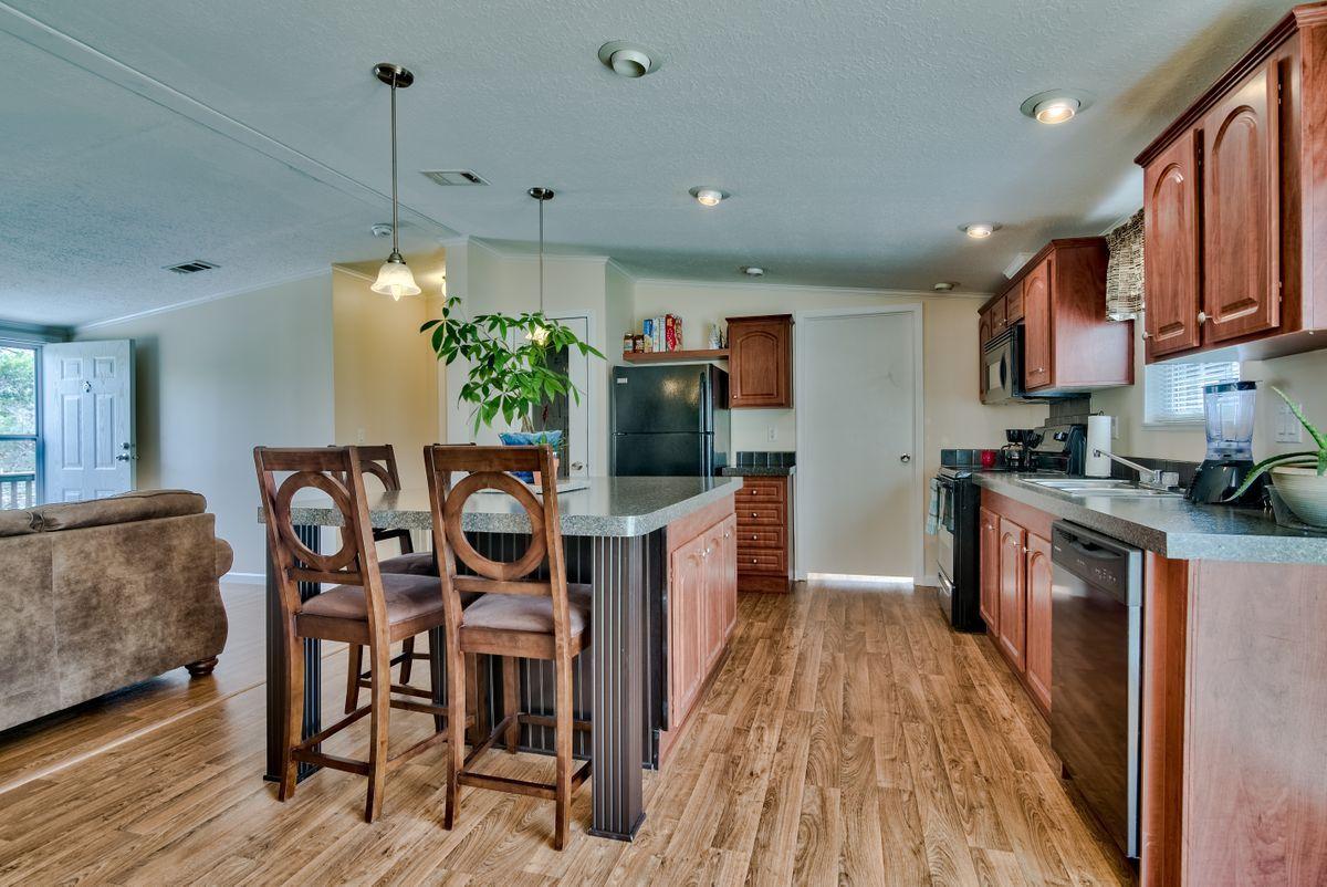 332 Don Graff Road Freeport, FL 32439 - Photo 14 of 33 a kitchen with stainless steel appliances granite countertop a stove top oven a sink a dining table and chairs with wooden floor
