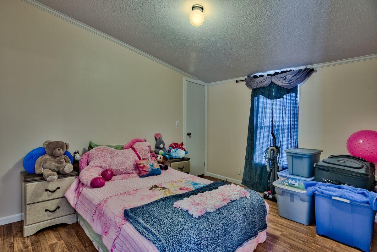 332 Don Graff Road Freeport, FL 32439 - Photo 19 of 33 a bedroom with a bed and a dresser in it