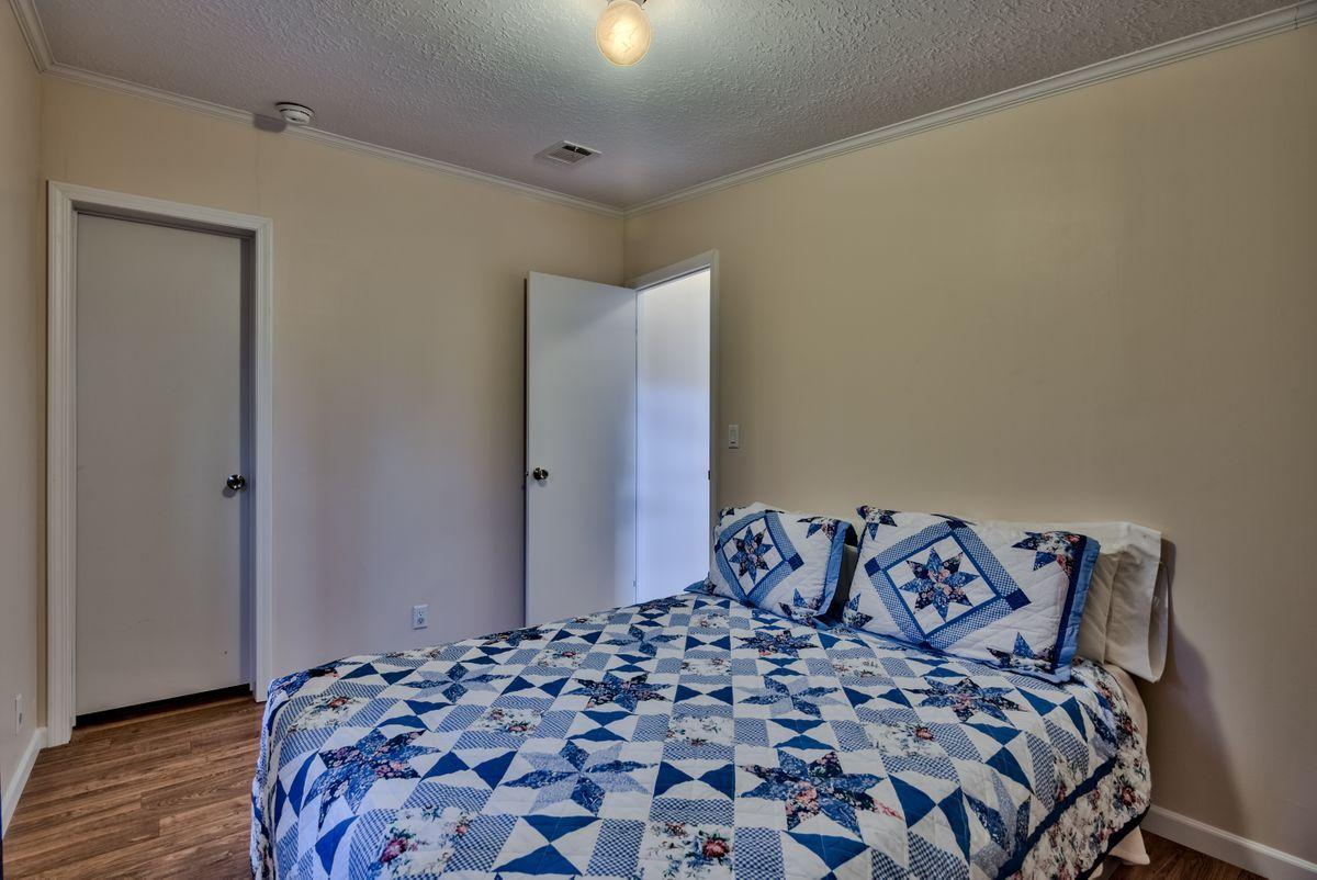 332 Don Graff Road Freeport, FL 32439 - Photo 22 of 33 a bedroom with a large bed and a wooden floor