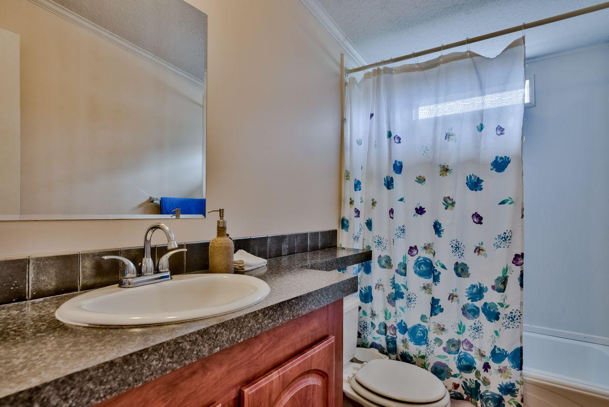 332 Don Graff Road Freeport, FL 32439 - Photo 23 of 33 a bathroom with a granite countertop sink and a mirror