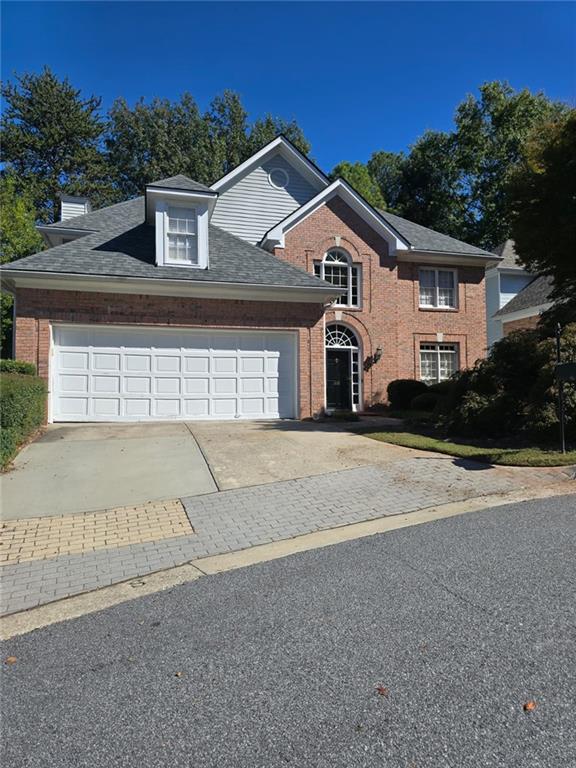 232 Spalding Gates Drive Northeast Atlanta, GA 30328 - Photo 2 of 12 a front view of a house with a yard and garage