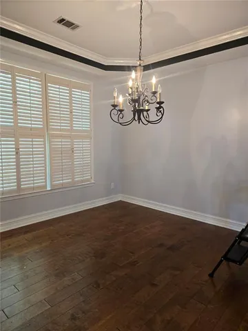 a view of empty room with wooden floor fan and window