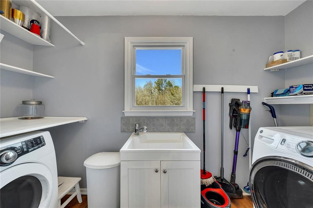 2133 Mann Road Douglasville, GA 30134 - Photo 29 of 69 a utility room with dryer washer and a wooden floor
