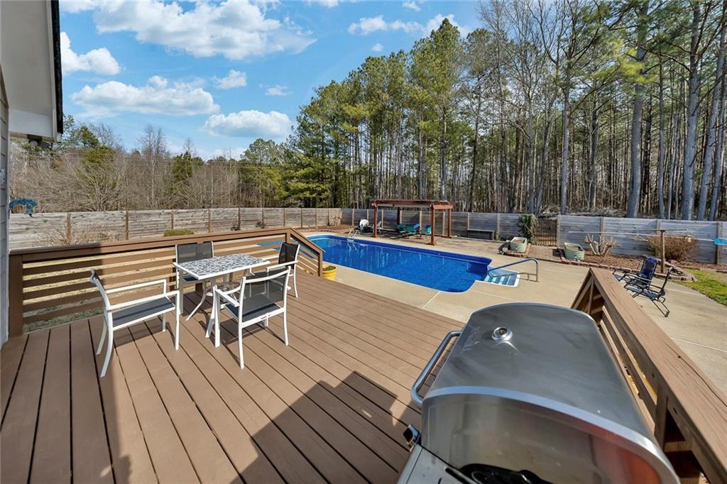 2133 Mann Road Douglasville, GA 30134 - Photo 49 of 69 a view of a patio with dining table and chairs with wooden floor and fence