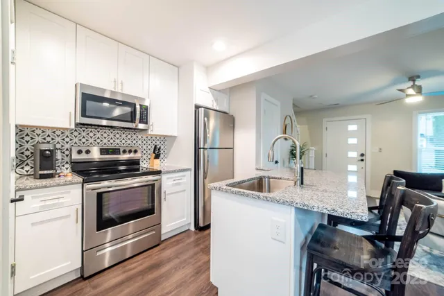 a kitchen with kitchen island a stove a sink and a refrigerator