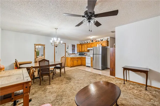 a dining room with a table chairs and a kitchen view