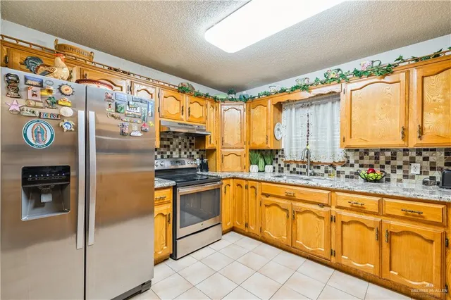 a kitchen with stainless steel appliances granite countertop a stove a sink and a microwave