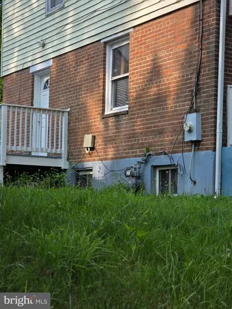 a backyard of a house with wooden fence and large windows