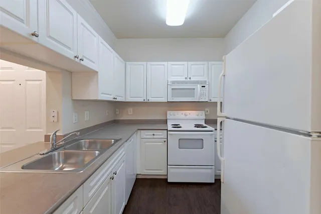 a kitchen with a sink stove top oven and cabinets