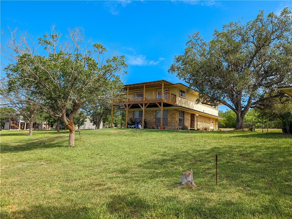 155 Buffalo Road George West, TX 78022 - Photo 2 of 39 a big yard with large trees and a wooden fence