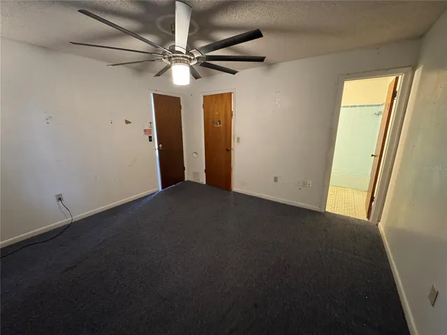 an empty room with a ceiling fan and a window