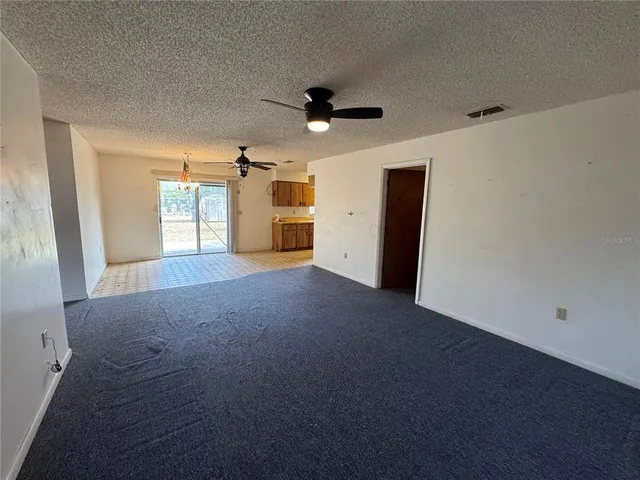 a view of a livingroom with a ceiling fan and window