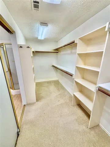 a view of walk in closet with empty racks