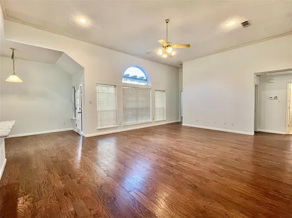 an empty room with wooden floor and window