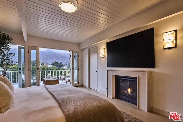 a bed room with a fireplace and a television