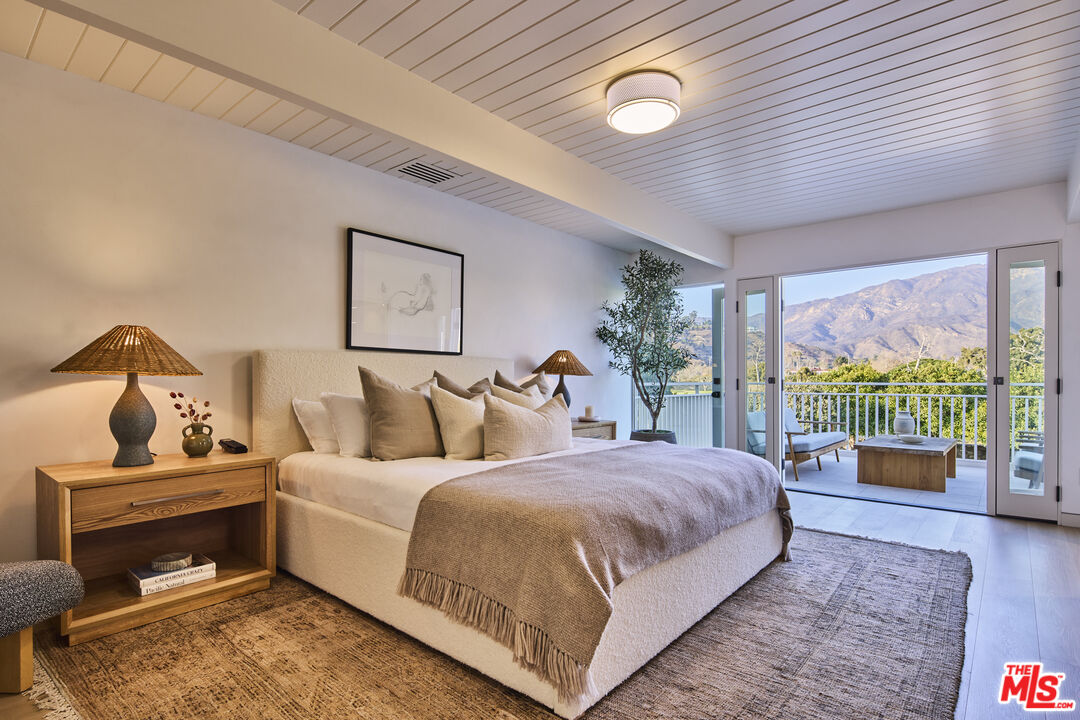 23515 Malibu Colony Road Malibu, CA 90265 - Photo 10 of 22 a bedroom with a bed and large windows