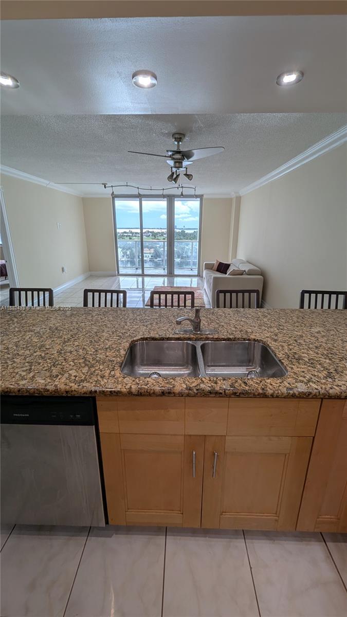 5701 Collins Avenue, Unit 1105 Miami Beach, FL 33140 - Photo 11 of 26 a kitchen with granite countertop a sink and a counter top space