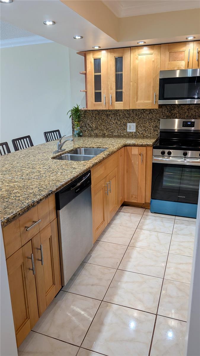 5701 Collins Avenue, Unit 1105 Miami Beach, FL 33140 - Photo 12 of 26 a kitchen with stainless steel appliances granite countertop a sink and a stove