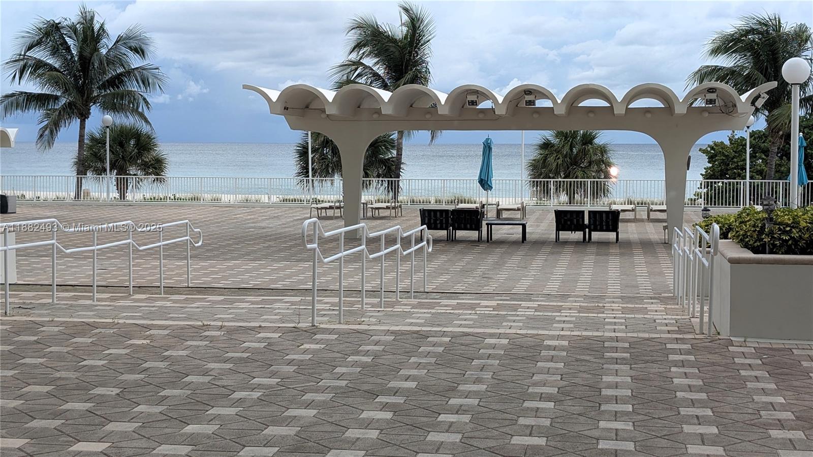 5701 Collins Avenue, Unit 1105 Miami Beach, FL 33140 - Photo 19 of 26 a front view of a building with glass windows and a table