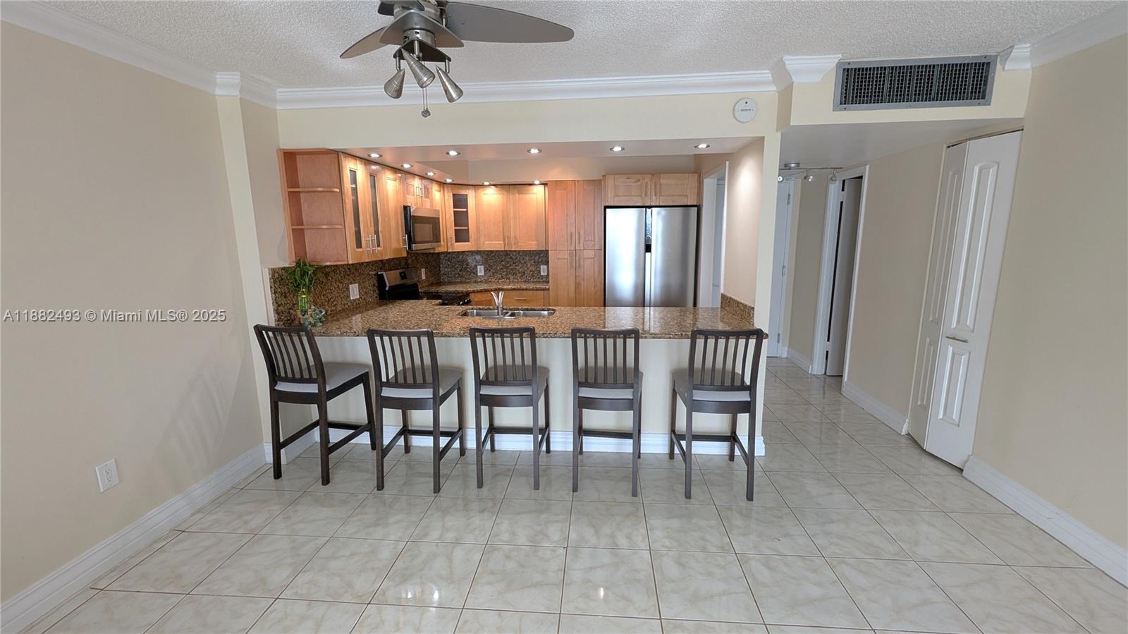 5701 Collins Avenue, Unit 1105 Miami Beach, FL 33140 - Photo 8 of 26 a dining room with furniture and a chandelier
