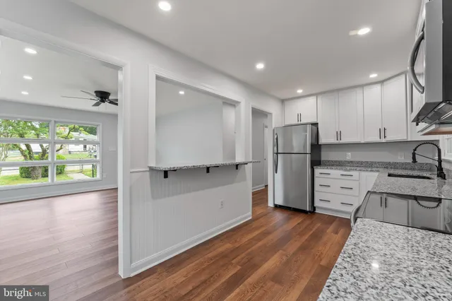 a kitchen with stainless steel appliances granite countertop a refrigerator and a stove top oven