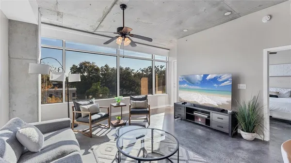 a living room with furniture a flat screen tv and a window