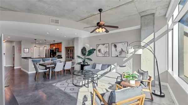 a view of a dining room and livingroom with furniture wooden floor a chandelier