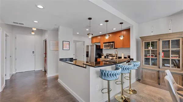 a kitchen with stainless steel appliances kitchen island granite countertop a table and chairs in it