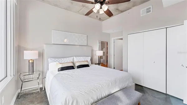 a bedroom with a bed and a ceiling fan