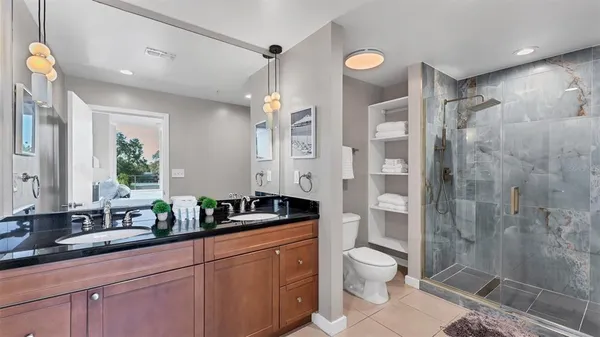 a bathroom with a double vanity sink toilet and shower