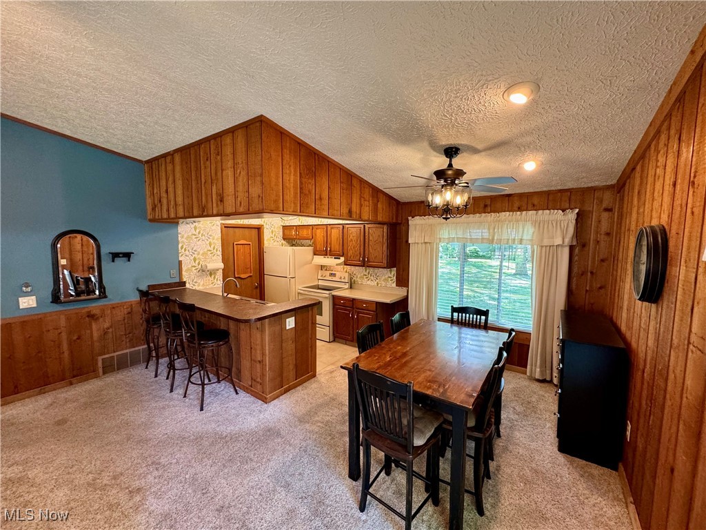 1499 Welch Road Painesville, OH 44077 - Photo 10 of 22 Kitchen with white appliances, light colored carpet, and a textured ceiling