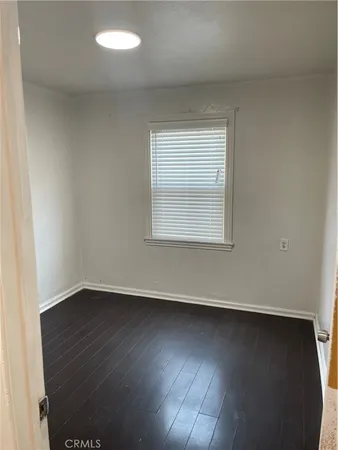 an empty room with wooden floor and a window