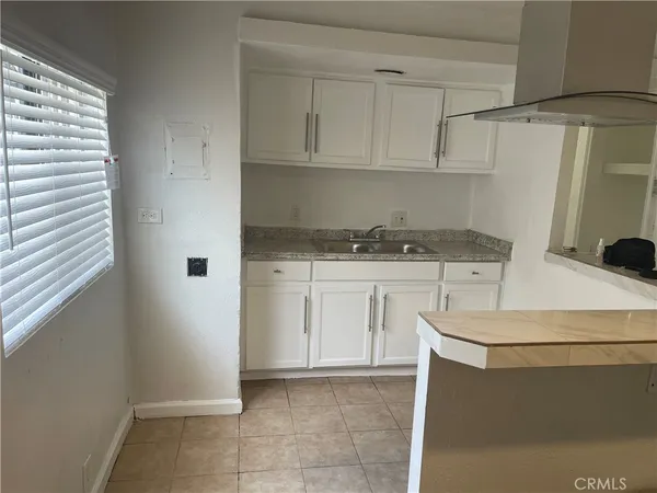 a kitchen with white cabinets and white appliances