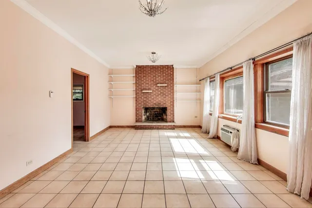 a view of an empty room with window and fireplace