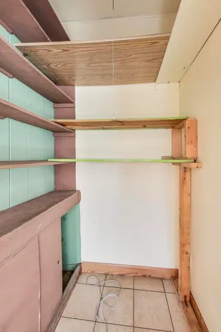 a view of a hallway with wooden shelves