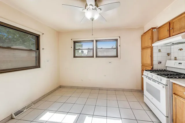 a kitchen with a stove a refrigerator and cabinets