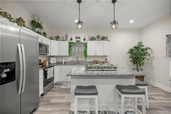a kitchen with refrigerator and white cabinets